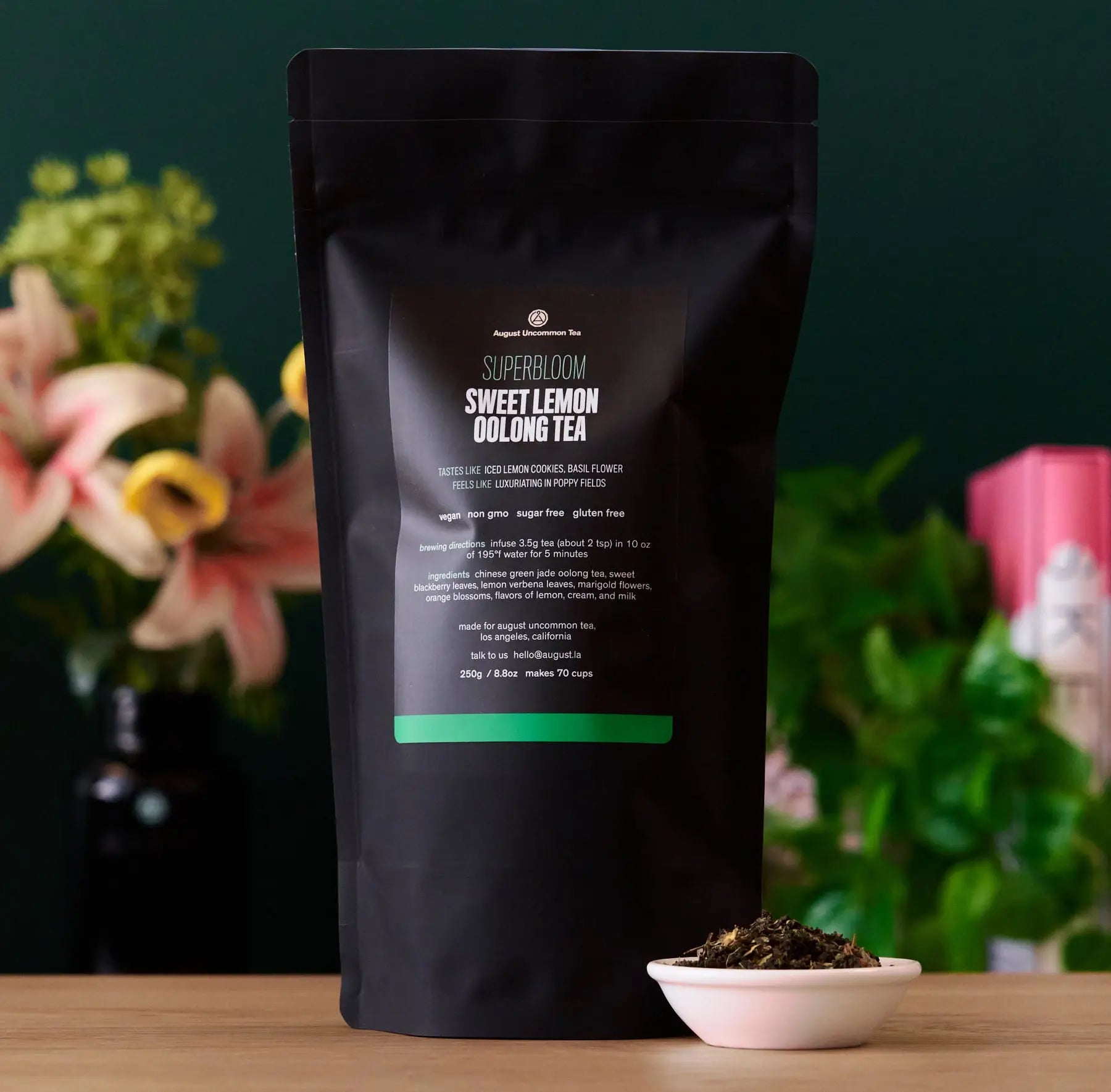 Superbloom Sweet Lemon Oolong Green Tea with lemon flowers and green leaves in a clear cup